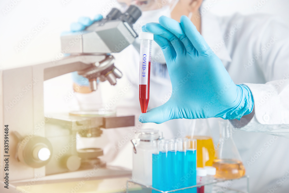 Fototapeta premium Scientist working with microscope in lab.Hold experimental Blood tube. Laboratory research concept..About experimental science such as chemical mixing or data entry to develop vaccines for everyone