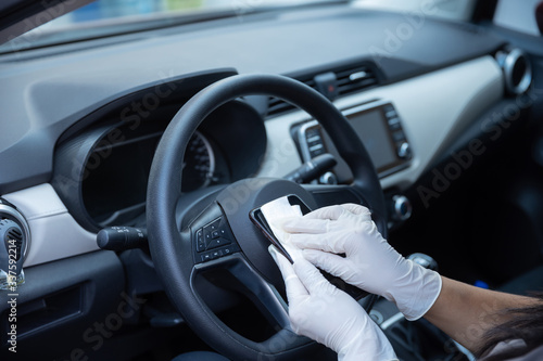 person with gloves cleaning cell phone inside car due to coronavirus pandemic in mexico, covid19