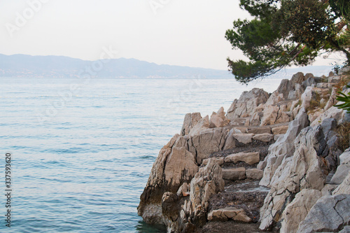 Marble gray steps on the shore of the blue sea