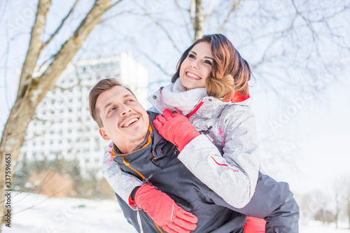 Beautiful young happy couple caucasian man and sexy girl having fun together, hugging and laughing outdoors in winter, lifestyle vacation, romantic leisure weekend, happy holiday, people, season, love