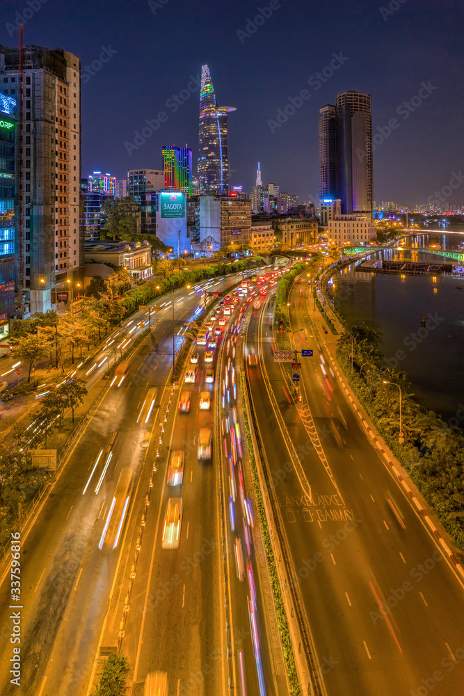 Aerial panoramic cityscape view of HoChiMinh City and the entrance of the Saigon River tunnel , Vietnam with blue sky at sunset.  