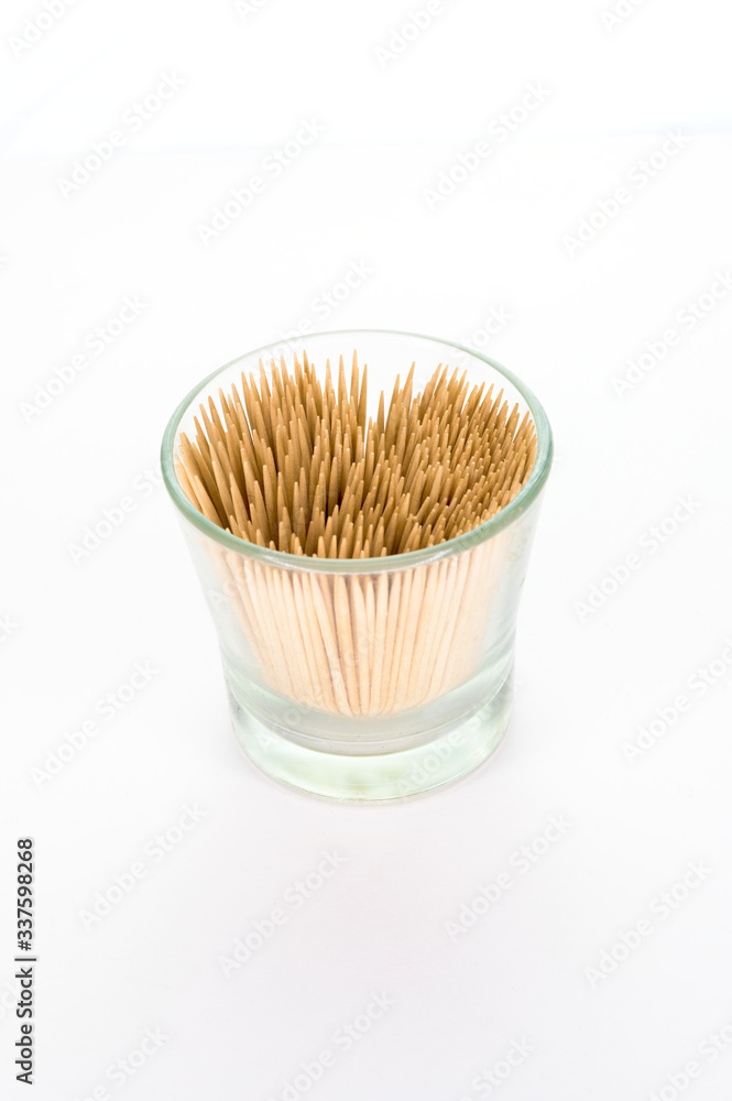 A small glass filled with toothpicks, isolated on white background A small glass filled with toothpicks, isolated on white background
