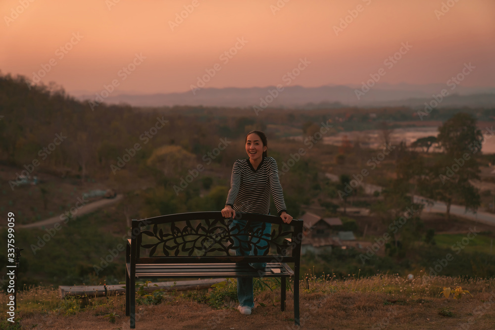 hipster girl posing smile relaxing on bench with holiday relaxing on the mountain in sunset at Northeast at Chiangkhan of Thailand hipster girl posing smile relaxing on bench with holiday relaxing on the mountain in sunset at Northeast at Chiangkhan of Thailand