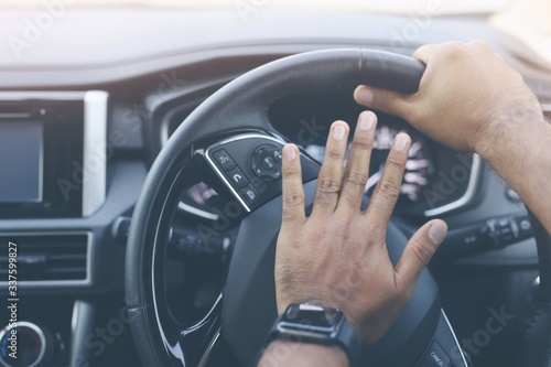 The man honk the horn in the car