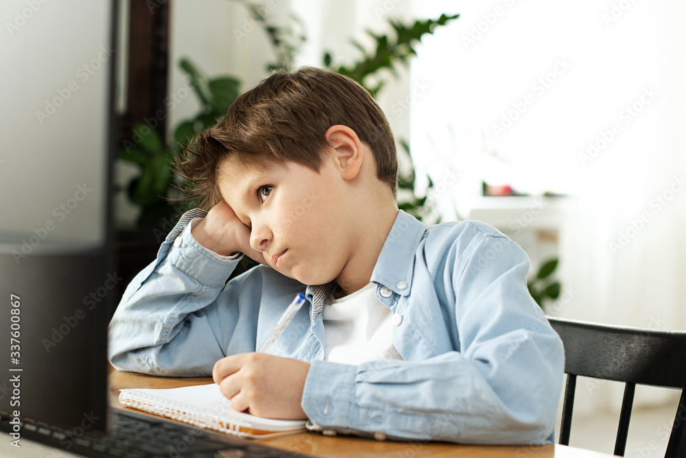 Distance learning during isolation during quarantine in coronovirus. Boy and laptop at home. Lifestyle Distance learning during isolation during quarantine in coronovirus. Boy and laptop at home. Lifestyle