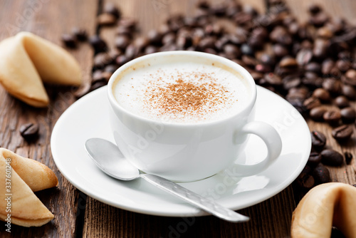 Cup of cappuccino coffee with cinnamon on wooden table. © Nelea Reazanteva