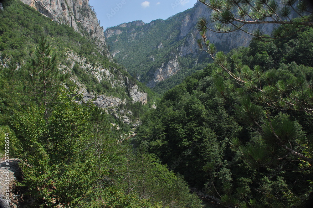 The bridge on the Tara River in Montenegro and the bridge connecting the two banks of the canyon. A stony bed of a clean river flowing through the valley along the road on a mountain slope. The bridge on the Tara River in Montenegro and the bridge connecting the two banks of the canyon. A stony bed of a clean river flowing through the valley along the road on a mountain slope.