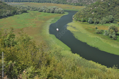 Rijeka Crnojevića, part of the Skadar Lake in Montenegro. Tourist cruises by boat on the beautiful meanders of the river flowing between the hills. photo