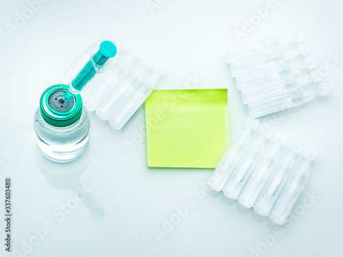 Vaccination and immunization concept. Close up shot on the vial with syringe, Ampoules and note