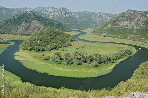 Rijeka Crnojevića, part of the Skadar Lake in Montenegro. Tourist cruises by boat on the beautiful meanders of the river flowing between the hills. photo