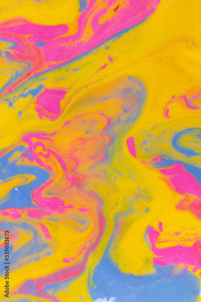 Abstract background of mixed shades of nail polish with a marble pattern. Liquid colorful paint background creative watercolor neon pink, blue, yellow