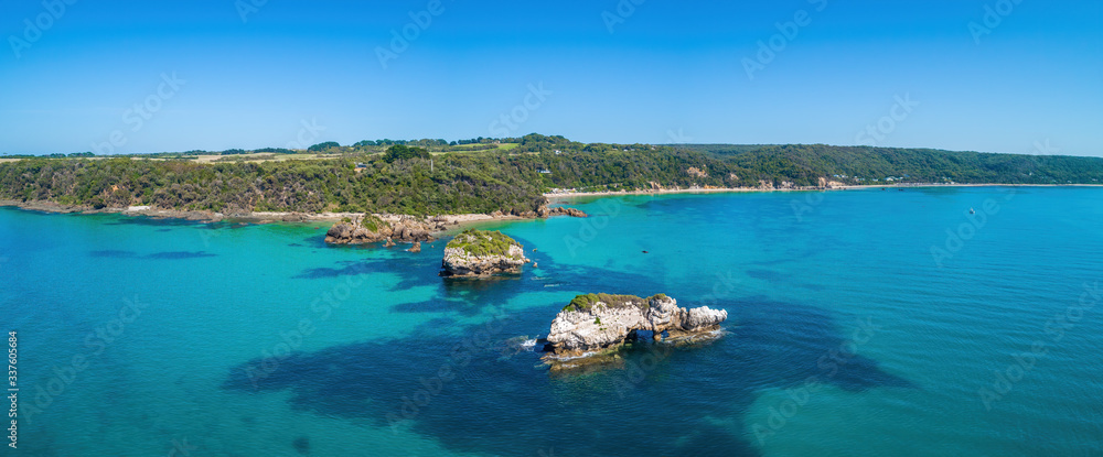 Aerial panorama of scenic ocean coastline with rocks and shallow turquoise water near Walkerville South in Victoria, Australia