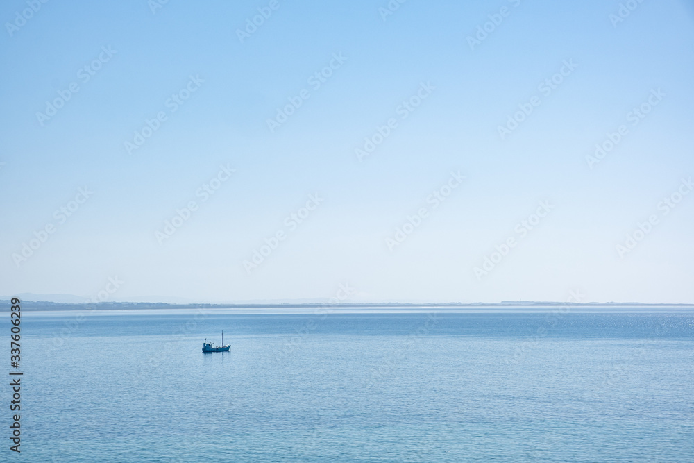Fishing boat in the blue ocean with copy space - minimalist landscape
