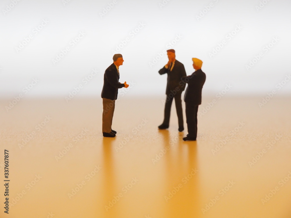A miniature businessman persuading colleague in the office. A miniature businessman persuading colleague in the office.