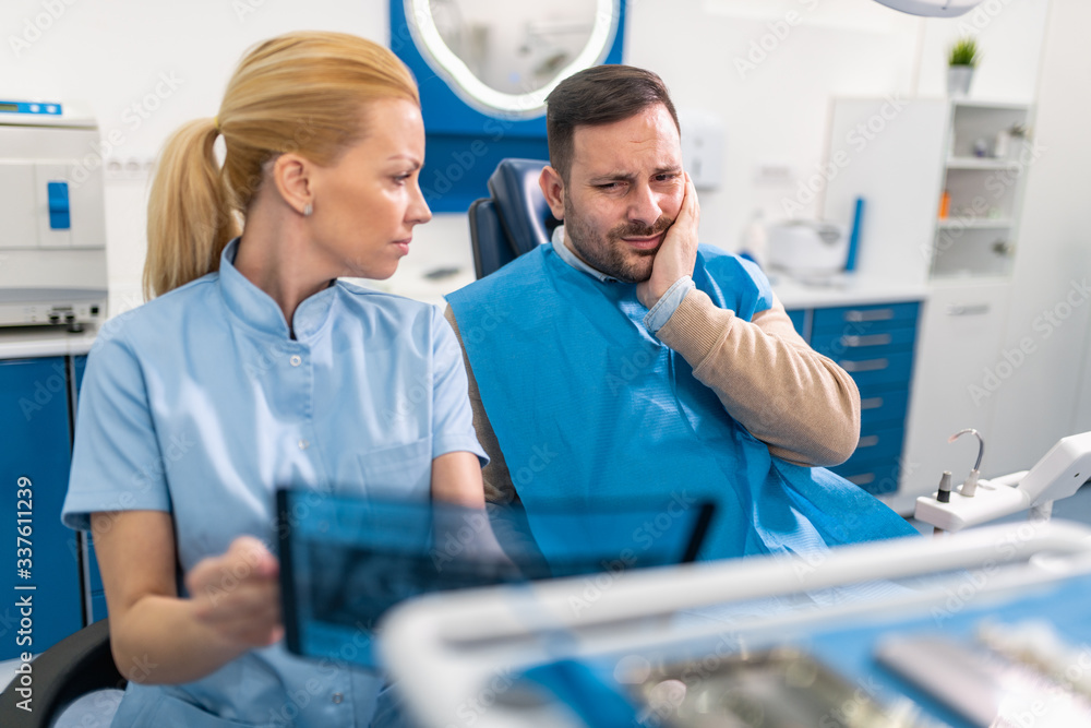 Dentist explaining x ray picture to patient. Dentist explaining x ray picture to patient.