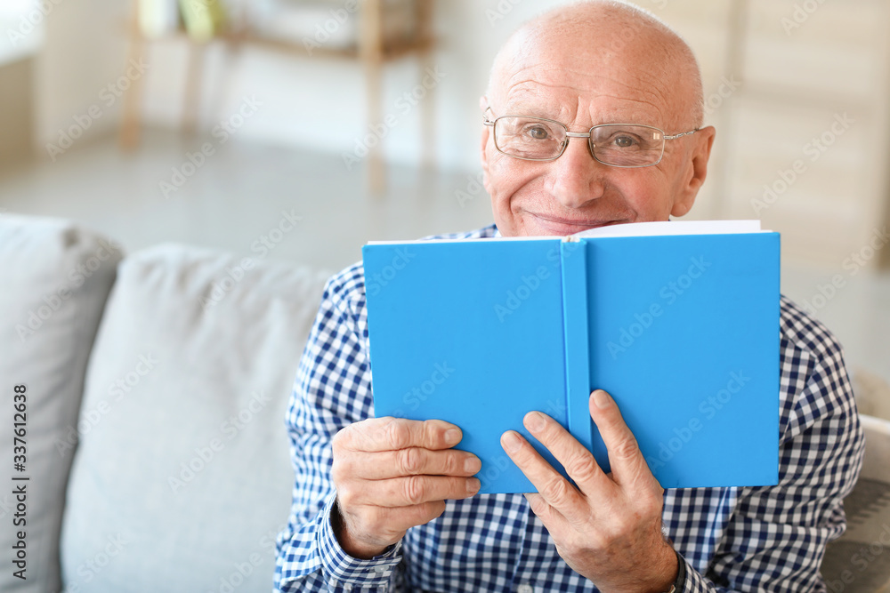 Elderly man reading book at home Elderly man reading book at home