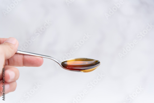 Honey in a spoon Held by a woman's hand