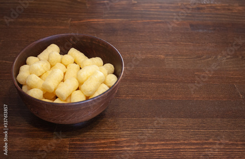 Corn sticks in a clay plate on a wooden table