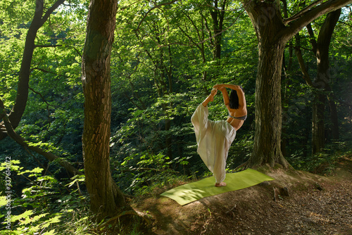 Yoga in natural. Portrait of happiness young asian woman practicing yoga outdoors. Yoga and relax concept. Beautiful girl practice asana in green forest at sunset