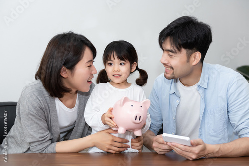 Young Asian mom and dad are saving money with daughter