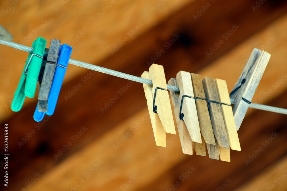Concept love and togetherness without people. clothespins on a rope on a wooden background. middle clothespin in focus Concept love and togetherness without people. clothespins on a rope on a wooden background. middle clothespin in focus