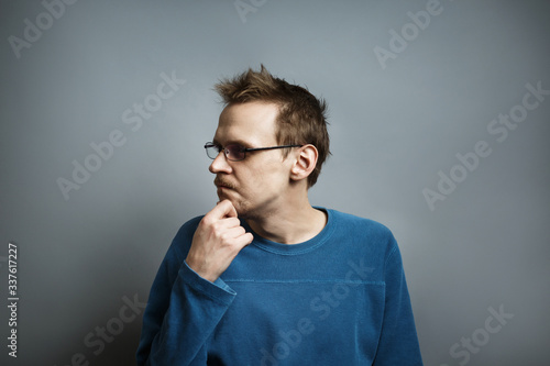Young guy with glasses looks at the side