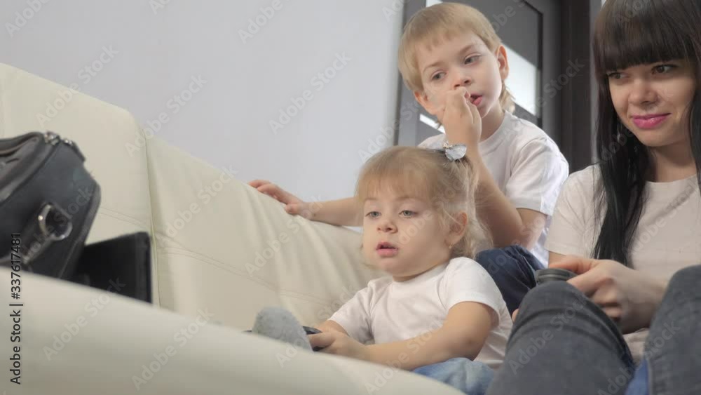 mother and children play console in gamepads teamwork. mom and kids a boy and a girl are playing a portable set-top box in TV controller. happy family little boy and lifestyle girl have online fun mother and children play console in gamepads teamwork. mom and kids a boy and a girl are playing a portable set-top box in TV controller. happy family little boy and lifestyle girl have online fun