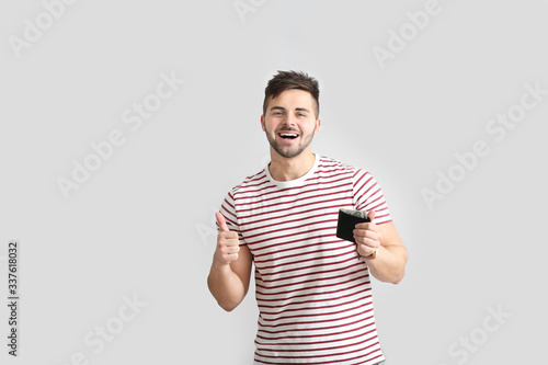 Happy man with purse on lig...