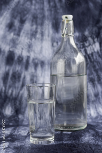 selective focus, a glass of water with a bottle