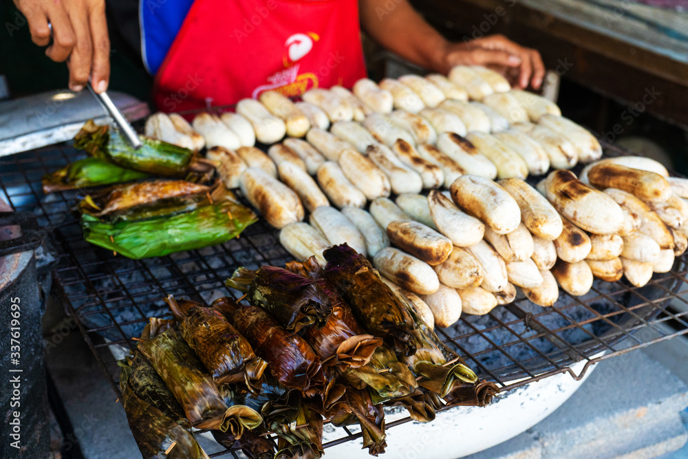 A street food vendor in Asia sells fried bananas and other snacks.