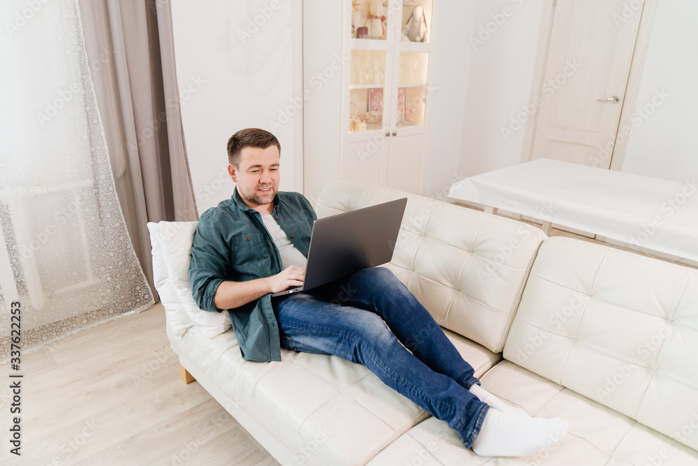 male blogger working online lying on the couch. male blogger working online lying on the couch.