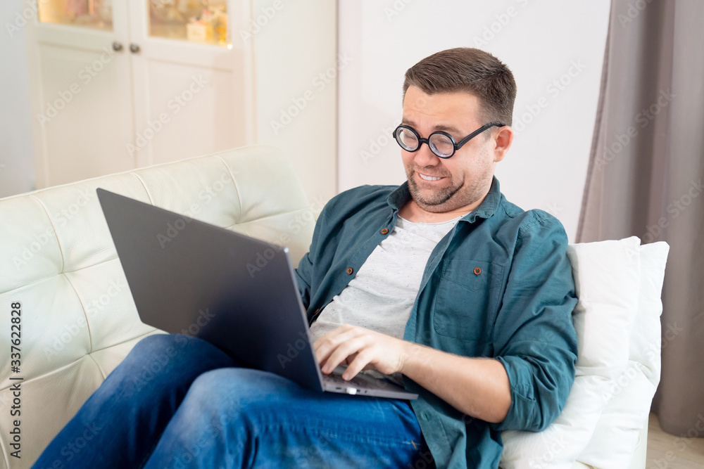 funny freak with glasses working lying on couch. funny freak with glasses working lying on couch.