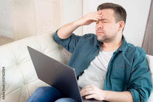 businessman with head hurts working lying on couch