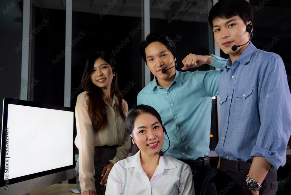 Asian call center business people working late night shift for helping assistance customer brainstorm about invesment profit in office workplace at night time Asian call center business people working late night shift for helping assistance customer brainstorm about invesment profit in office workplace at night time