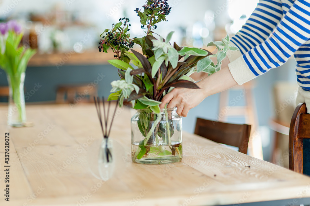 陽の光が明るいカフェ レストランのテーブルの上の花瓶に花束を生けるシーン Stock Photo Adobe Stock