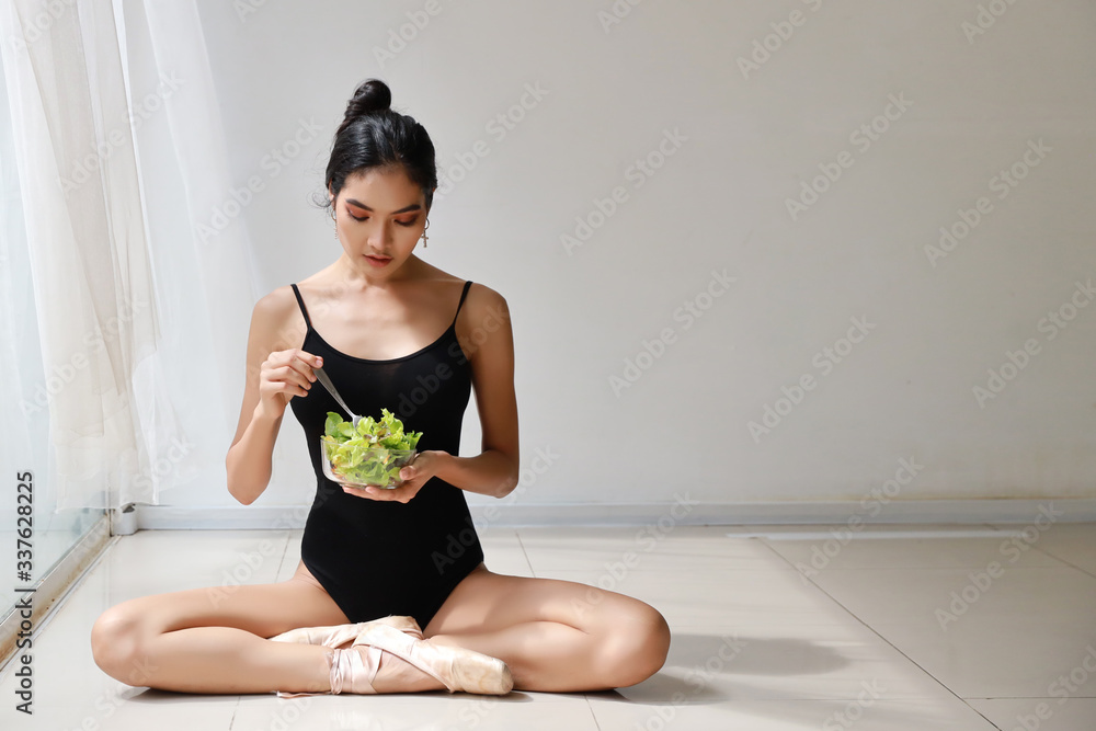 beautiful healthy and sporty asian young woman holding salad bowl and eat after training ballet dancing while sitting with relaxation beautiful healthy and sporty asian young woman holding salad bowl and eat after training ballet dancing while sitting with relaxation