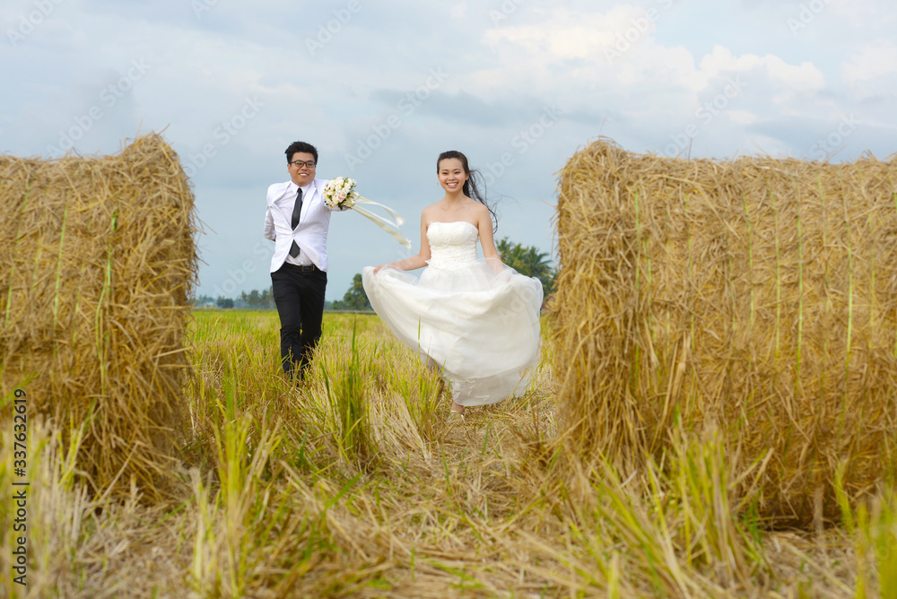 Asian bride and groom run at the paddy field Asian bride and groom run at the paddy field