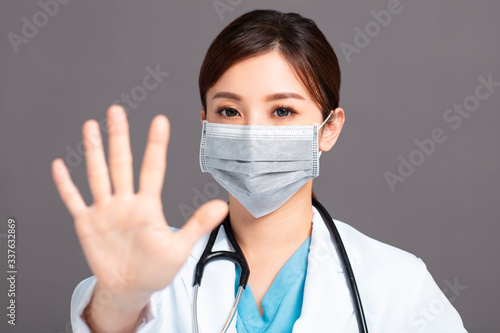  female doctor wearing face mask in prevention for coronavirus showing gesture Stop sign