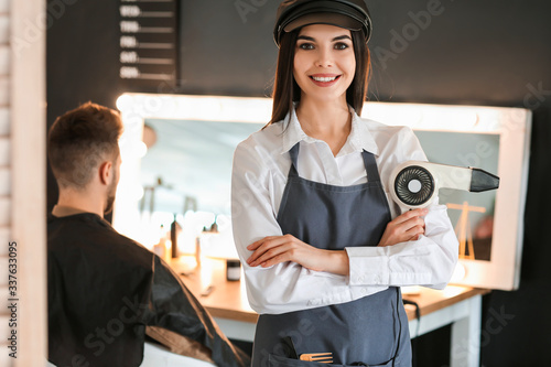 Smiling female hairdresser ...