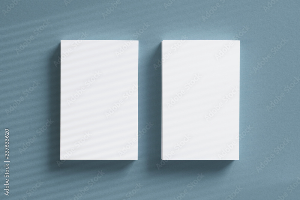 Top view 2 of blank vertical business card stacks with window overlay shadow on grey textured background as template for design presentation, branding promotion etc. Top view 2 of blank vertical business card stacks with window overlay shadow on grey textured background as template for design presentation, branding promotion etc.