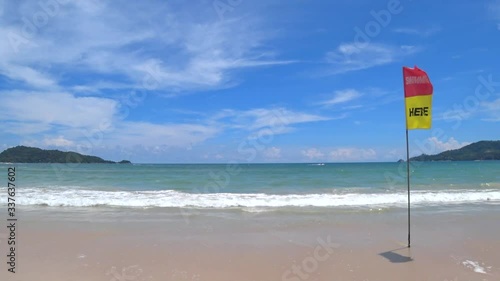 White foam wave running to the powdery sand with red and yellow 