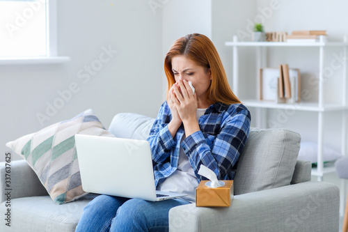 Sick woman with laptop at home