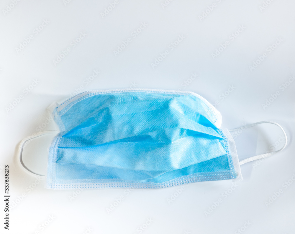 surgical face mask with rubber ear straps for protection against germs on white background
