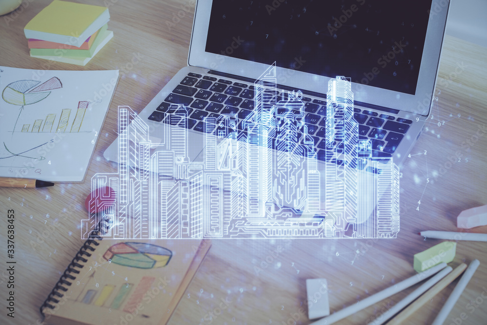 Desktop computer background in office and big town buildings hologram drawing. Double exposure. Smart city concept. Desktop computer background in office and big town buildings hologram drawing. Double exposure. Smart city concept.