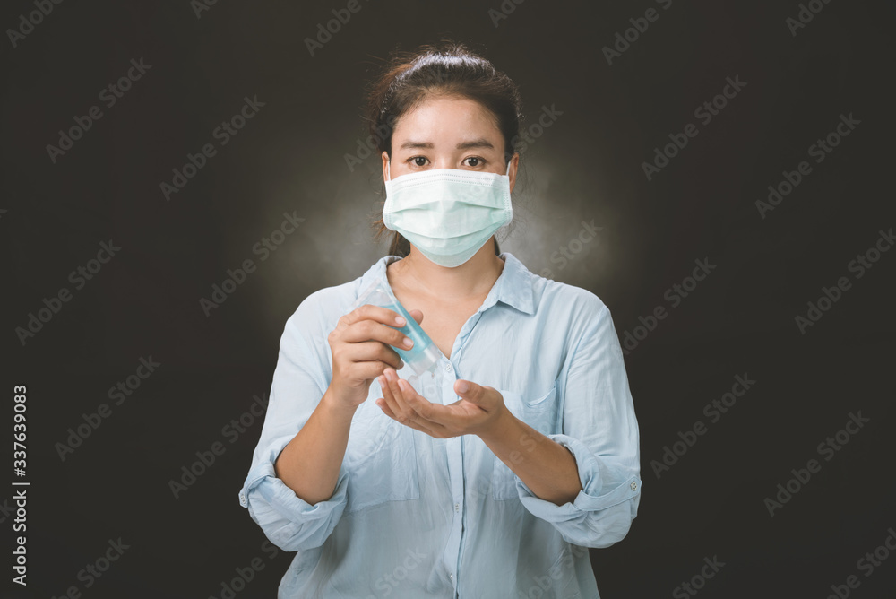 A picture of a girl in the studio wearing protection face mask against Resist infection coronavirus and Cleaning her hands with sanitizer gel. A picture of a girl in the studio wearing protection face mask against Resist infection coronavirus and Cleaning her hands with sanitizer gel.