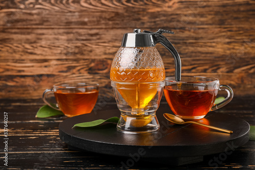 Jar of sweet honey with tea on table