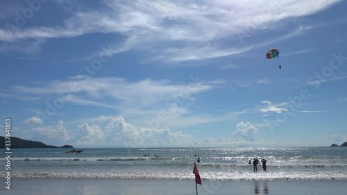 Parasailing in Patong beach, famous beach that full of tourists and a lot of activities, located in Phuket, Thailand.
