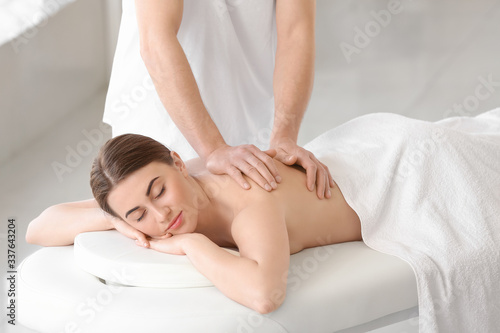 Massage therapist working with female patient in medical center