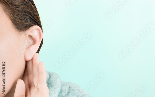 Young woman touching her ear on a blue background photo