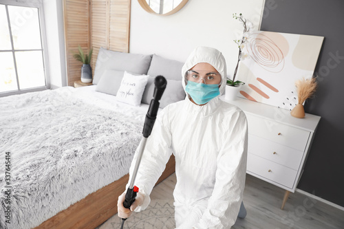 Worker in biohazard suit di...